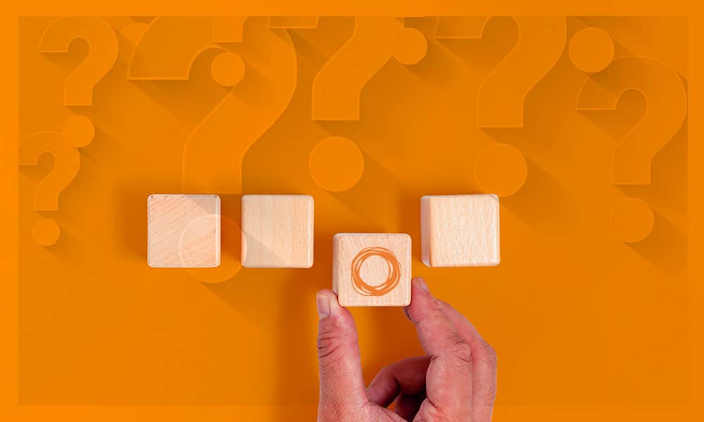 Image of hand choosing one of four blocks. Image accompanying blog post about How to choose Grant Management Software